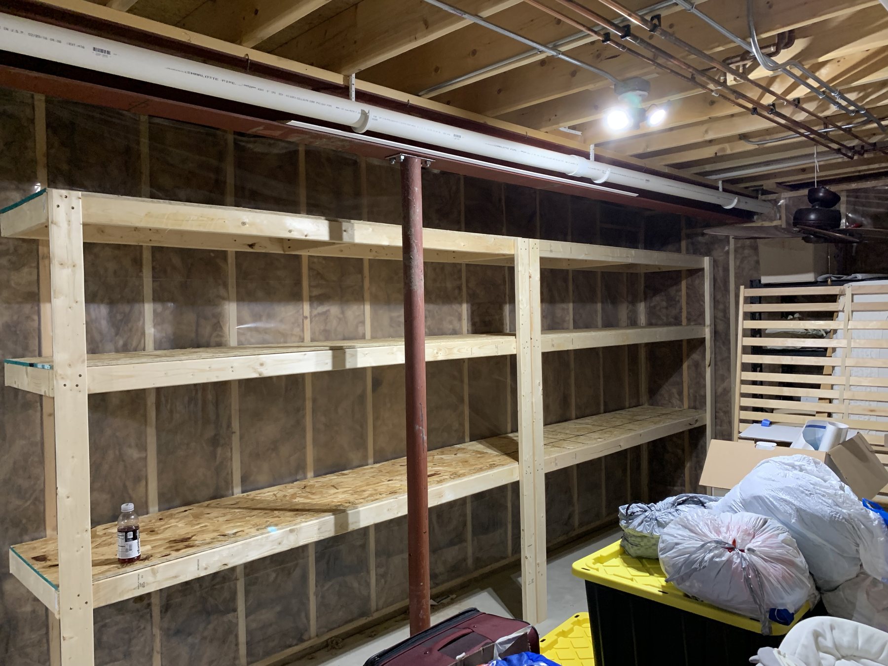 The same basement wall after Ray installed a run of custom wood shelving, with the floor completely clear.